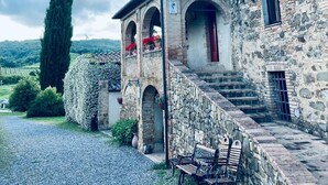Un edificio in pietra con un piccolo portico e dei gradini che conducono all'ingresso.