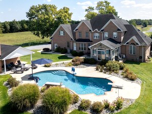 A large house with a swimming pool, a covered patio, and a well-maintained lawn. - Guest Lodge | Private Pool | Outdoor Dining | Game Room (Sudlerville)