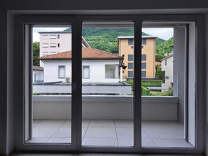 Condo económico, balcón | Área de sala de estar | Televisión de pantalla plana de 32 pulgadas con canales vía satélite 