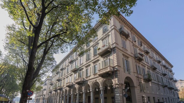 A multi-story building with classical architecture, featuring arched windows and balconies. - Ai Portici di Susa by Wonderful Italy (Turin)