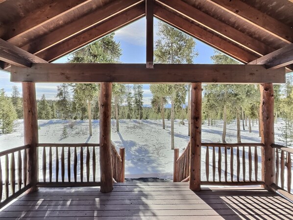 Un mirador de madera con vistas a un paisaje nevado y árboles.