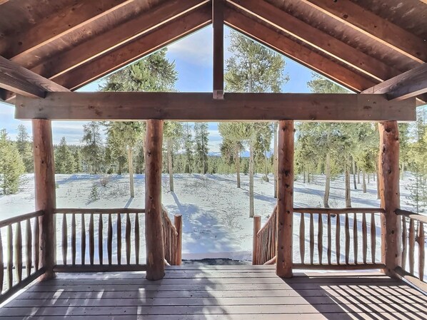 Un mirador de madera con vistas a un paisaje nevado y árboles.