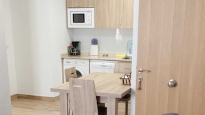 A compact living space with a kitchenette, a dining area, and a sofa. - HOSTAL LOS VALLES  (Bielsa)