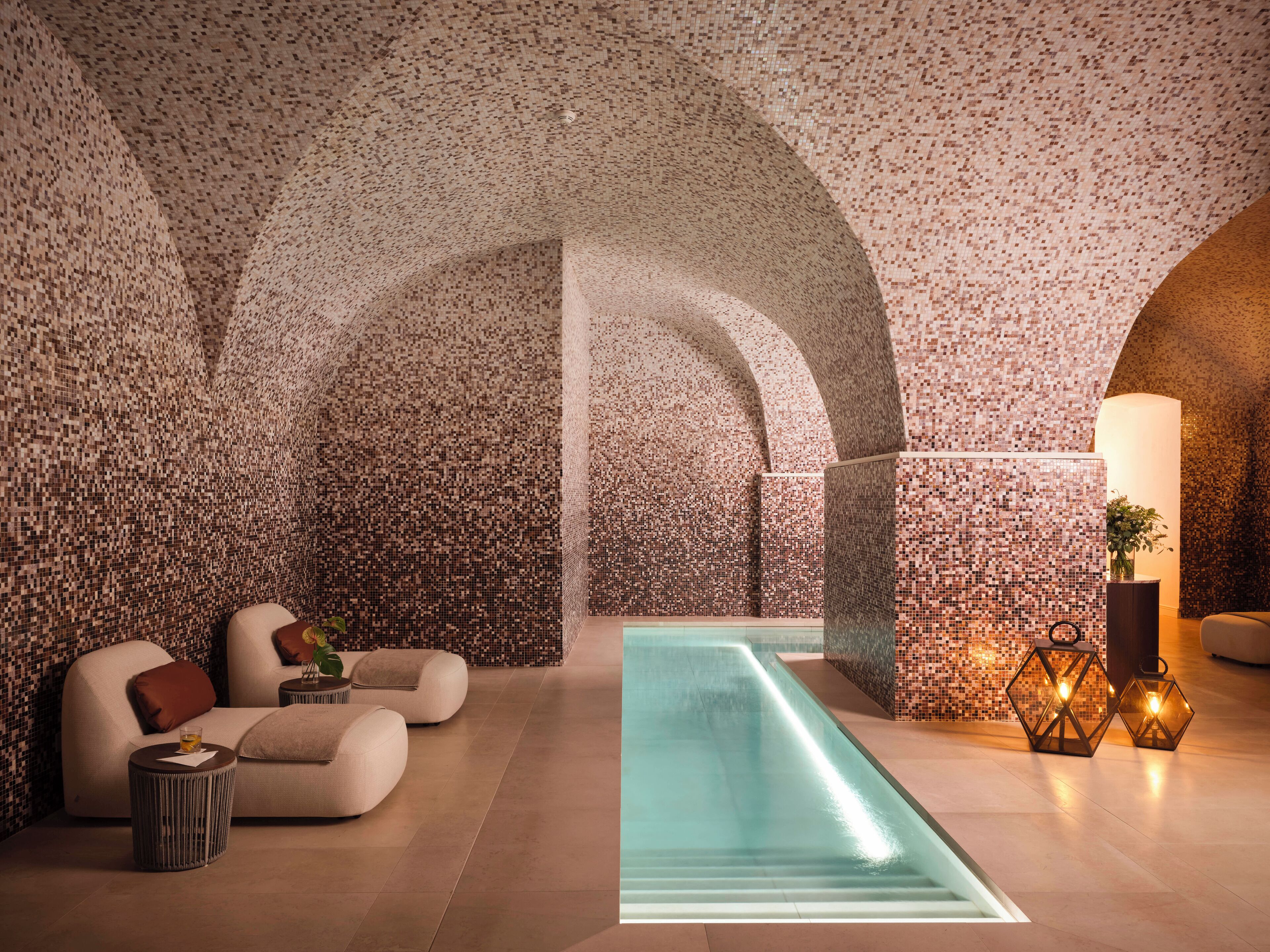 A modern spa area with a pool, seating, and decorative lighting.