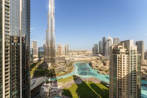 A high-rise building with a modern glass facade, surrounded by other high-rise buildings and a landscaped area with pathways and a small water feature. - Ultimate Living w/ Front-Row Views of Burj Khalifa & Dubai Fountains (Dubai)