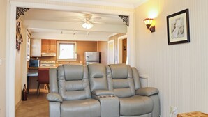 A living room with a gray leather sofa, a wooden coffee table, and a blue patterned rug. - ☀️2BR-Pet Friendly-1 Block from Beach-Off The Hook☀️ (St. Joe Beach)