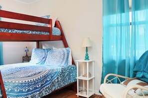 Cozy bedroom with a bunk bed, bedside table, and comfortable chair.