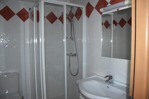 A bathroom with a glass-enclosed shower, a white sink, and a mirror above it. - 200m from ski slopes, 1st floor, balcony, tv, ski locker, 26m², Pralognan-la-Vanoise (Pralognan-la-Vanoise)