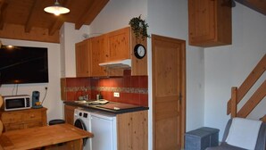 A compact kitchen with wooden cabinets, a microwave, a sink, and a washing machine. - 200m from resort center, 1st floor, balcony, tv, ski locker, 26m², Pralognan-la-Vanoise (Pralognan-la-Vanoise)