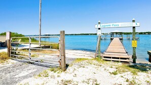 A wooden dock leading to a private dock area with a sign for Lagoon Pass Homeowner Association. - Lagoon Front | Pet Friendly | Boat Launch, Pier and Beach Access (Gulf Shores)