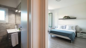 Un dormitorio moderno con cama, mesitas de noche y velador.