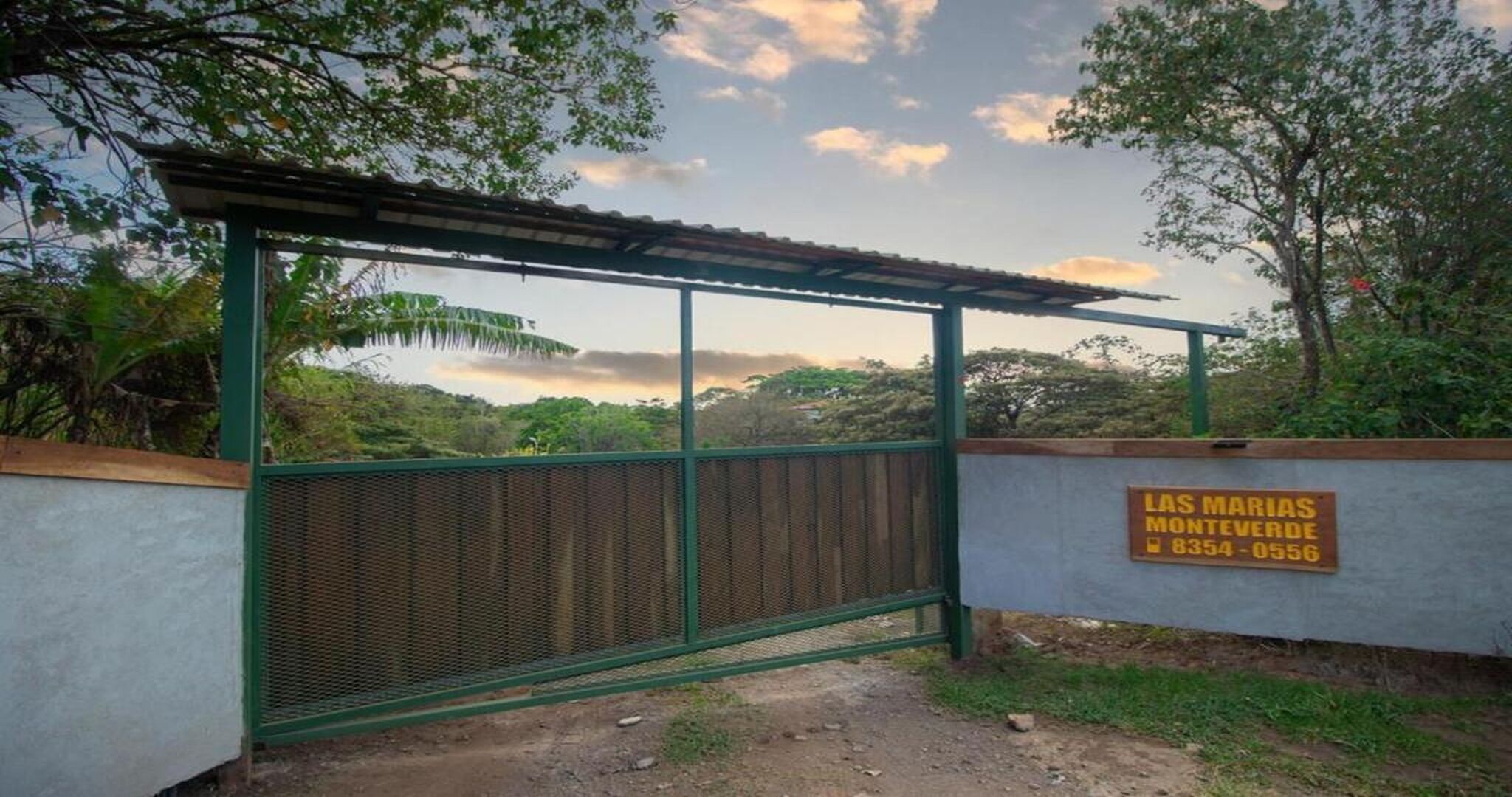 Ein verschlossenes Tor mit einem Schild, auf dem 'Las Marías Monteverde 8354-0556' steht.