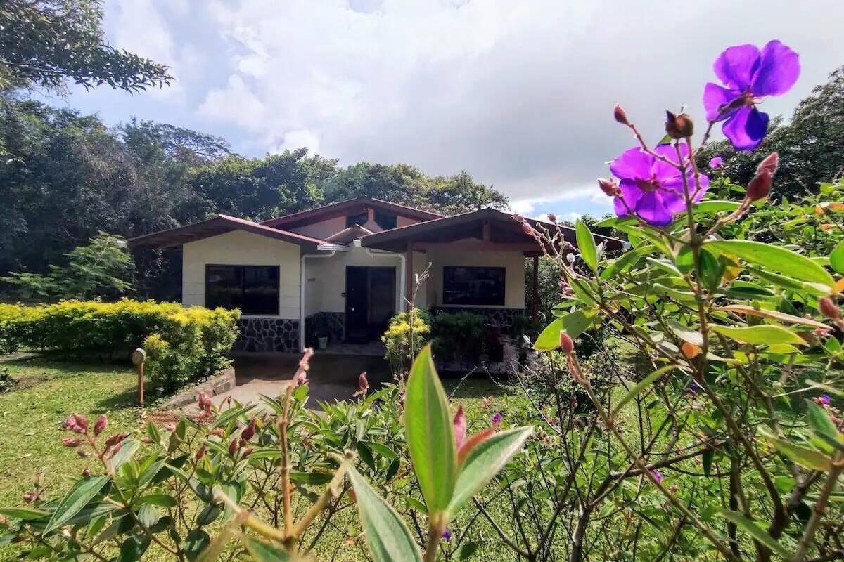 Una casa de dues plantes amb façana de pedra i un porxo.