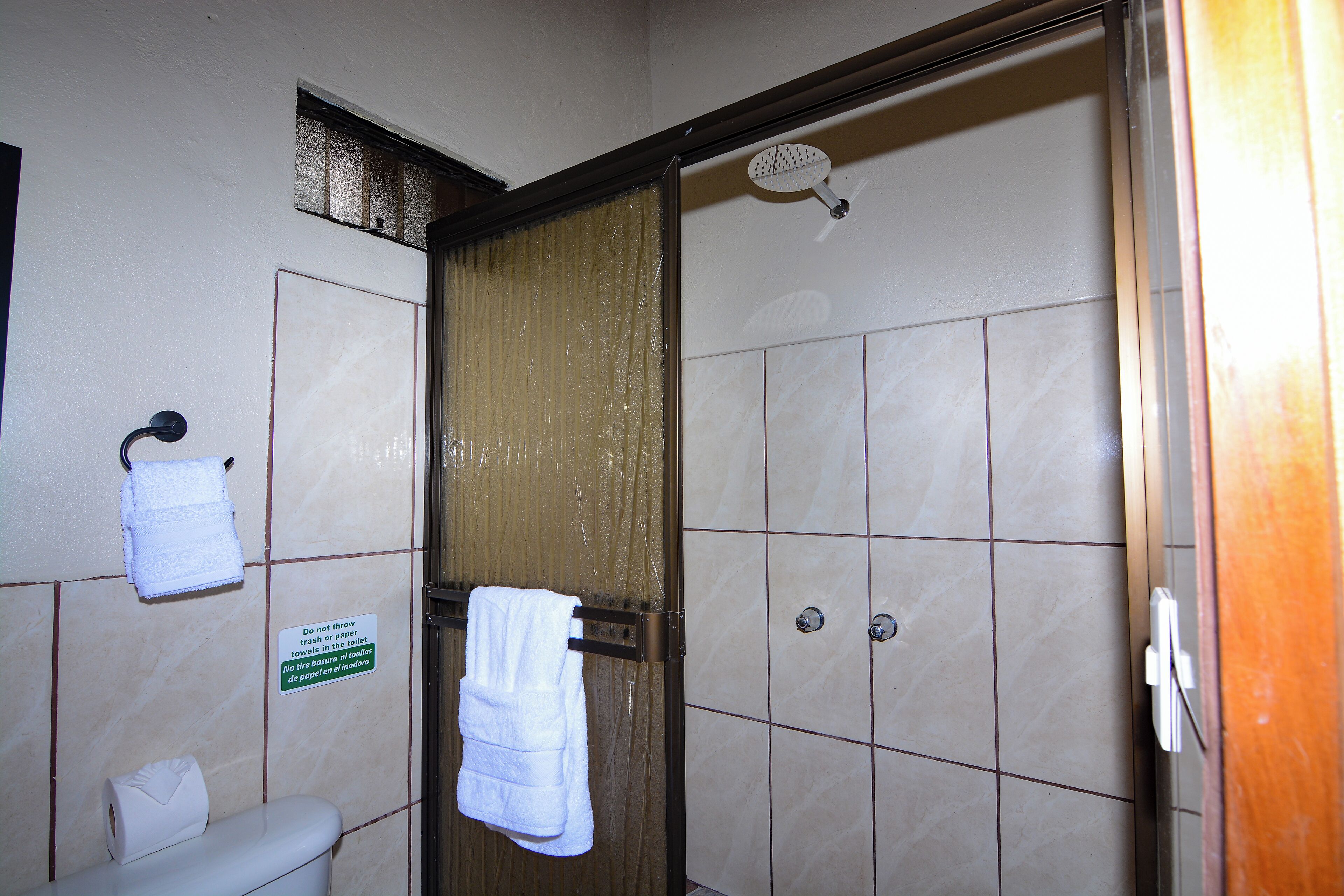 Een badkamer met douche, toilet en handdoekrek.