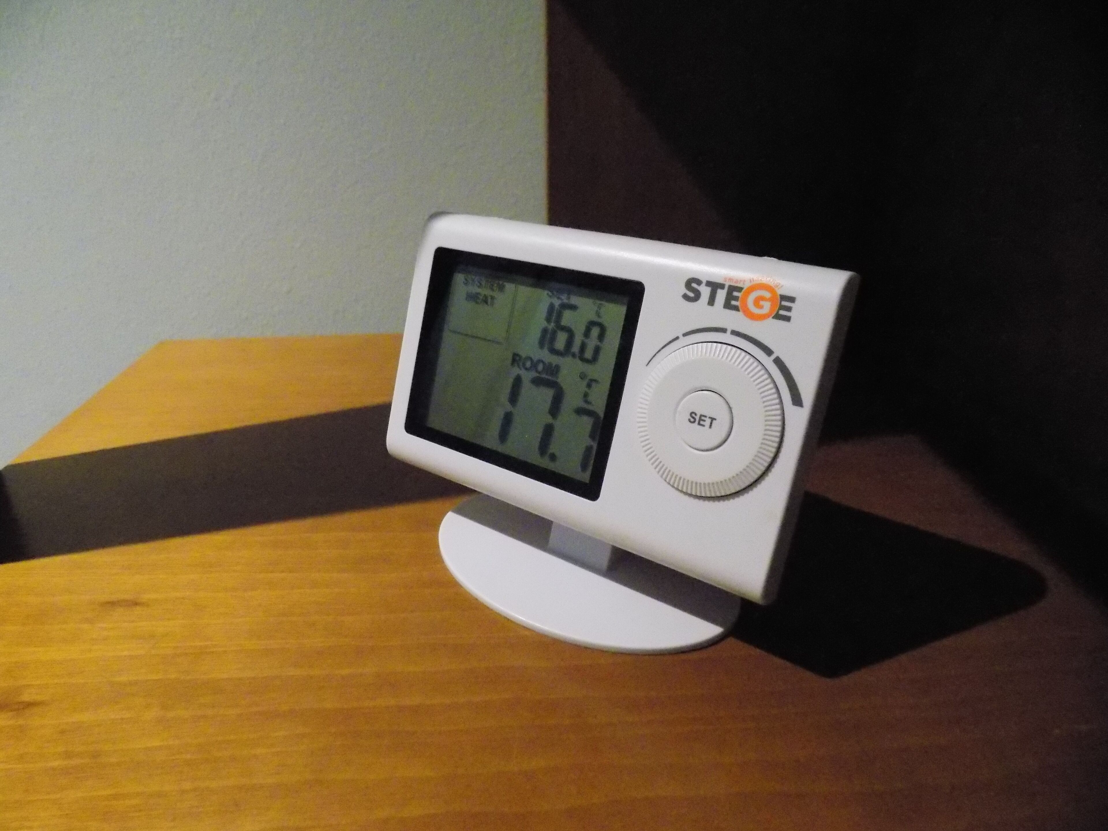 Un termostato digital sobre una superficie de madera.