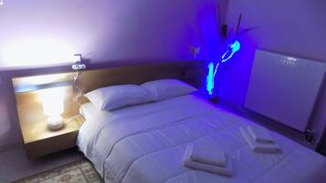 Una camera da letto con un letto, un comodino, una lampada e un lampadario blu.