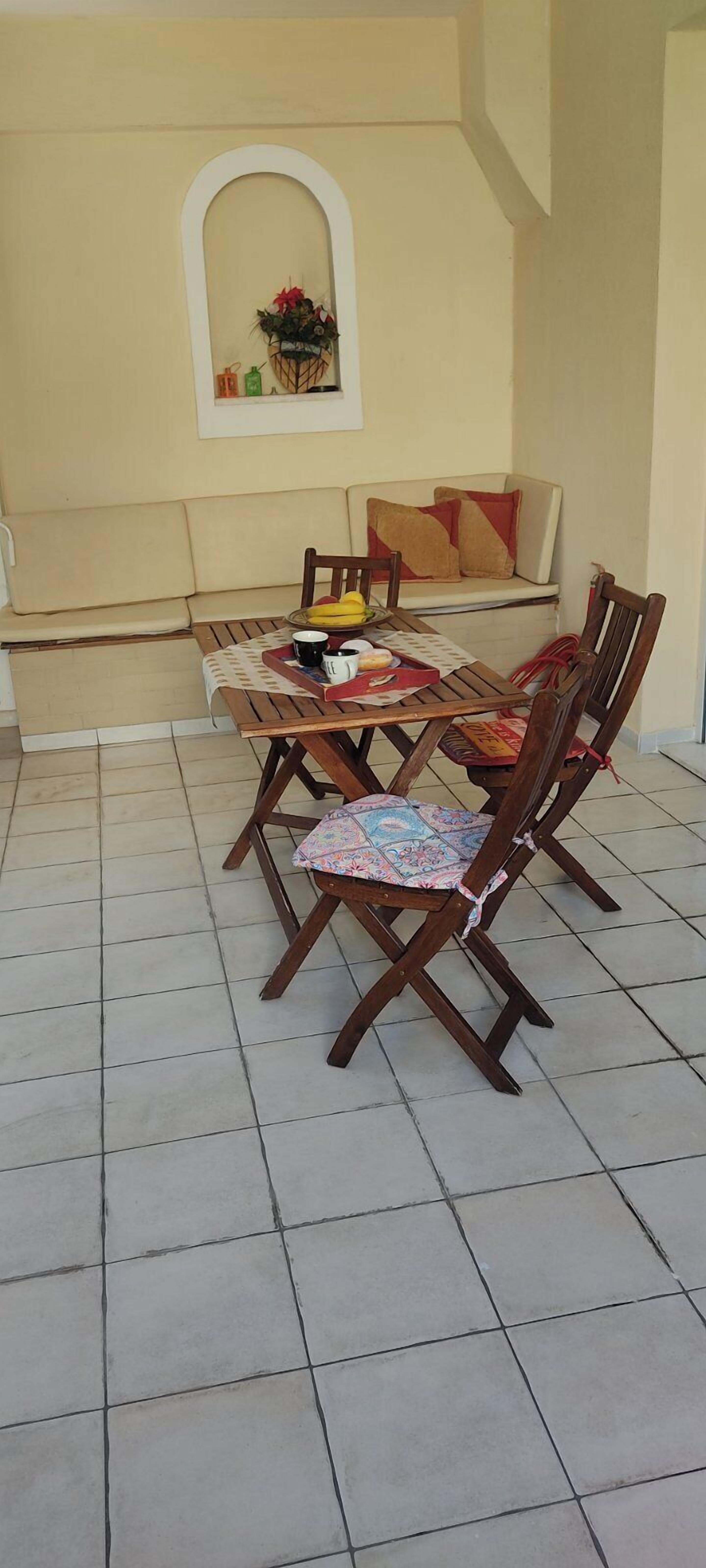 Ein Essbereich mit Holztisch und Stühlen, einer Couch und einer Wanddekoration.