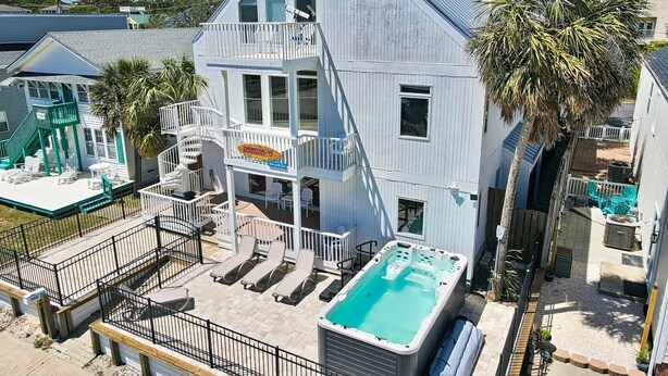 A multi-story building with a pool, outdoor seating, and a sign for Cherry Grove Beach House. - Wow By The Sea (North Myrtle Beach)