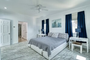 A bedroom with a bed, nightstands, a ceiling fan, and a door. - Pet/Student Friendly, Ocean Blvd (North Myrtle Beach)