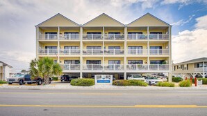 A three-story motel with balconies, a parking lot, and a sign reading "Grove Pointe." - Sunset at Sassy's 2 (North Myrtle Beach)