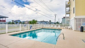 A swimming pool with a white fence, a lifeguard chair, and a lifeguard stand. - Sunset at Sassy's 2 (North Myrtle Beach)