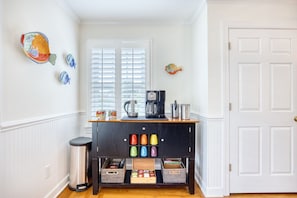 A kitchen with a coffee station, a trash can, and decorative fish wall art. - Luxury Home w/ Hottub & Elevator 1Block from Beach (North Myrtle Beach)