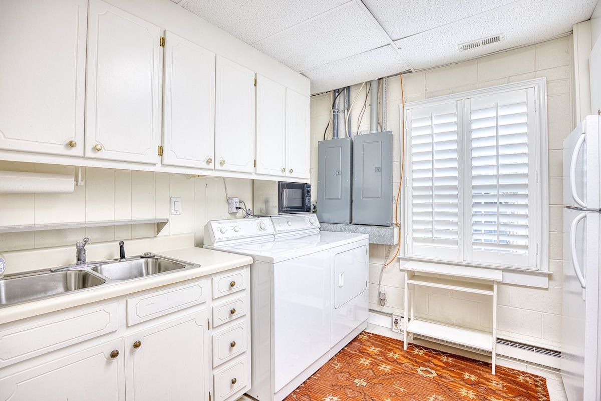 A compact kitchen with white cabinets, a built-in microwave, a stove, and a refrigerator.