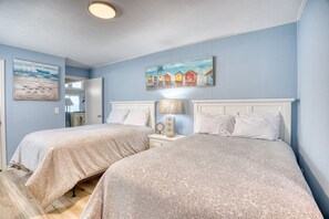 A bedroom with two beds, a nightstand with a lamp, and artwork on the walls. - OceanFront/Sleeps 14/Cherry Grove/Golfcart/Hottub (North Myrtle Beach)