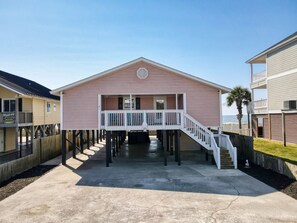 A beachfront property with a covered deck and a staircase leading to a second floor. - OceanFront/Sleeps 14/Cherry Grove/Golfcart/Hottub (North Myrtle Beach)