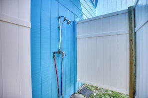A blue exterior wall with a white fence, a hose, and a metal pipe. - 4 BR House in Cherry Grove, 1 Block from beach (North Myrtle Beach)