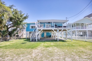 A two-story building with a covered outdoor area and a staircase leading to the upper level.