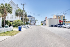 A street view with a white building, parked cars, and a clear sky. - 4 BR House in Cherry Grove, 1 Block from beach (North Myrtle Beach)