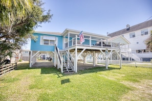 A two-story house with a covered porch and a flag. - 4 BR House in Cherry Grove, 1 Block from beach (North Myrtle Beach)
