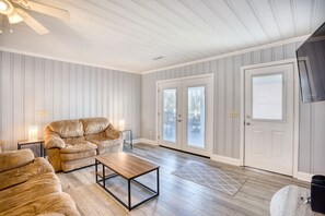A living room with a sofa, a coffee table, and a ceiling fan.