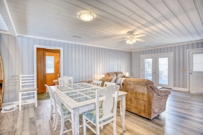 A room with a wooden ceiling, a dining table with chairs, a sofa, and a door with a window. - 4 BR House in Cherry Grove, 1 Block from beach (North Myrtle Beach)