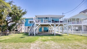 A two-story house with a balcony and a covered patio area.