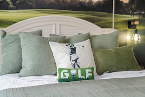 A bed with a headboard, multiple pillows, and a golf-themed pillow. - Large Luxury Water Front W/ Pool, HotTub, Elevator (North Myrtle Beach)
