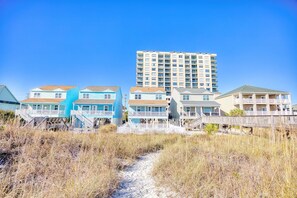 A beachfront property with multiple buildings, including a tall residential building and several houses with balconies.