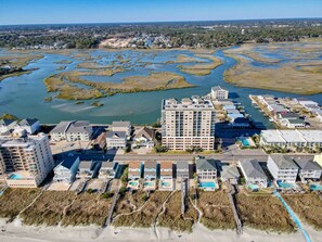 A coastal hotel with multiple buildings, including a large hotel and several smaller structures. There are visible swimming pools and a beach area. - 6 BR OceanFront w/ Heated Pool/Hottub Cherry Grove (North Myrtle Beach)