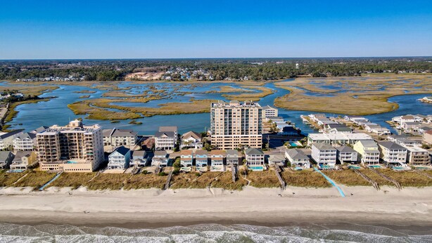 Une zone côtière comprenant un complexe hôtelier en bord de mer, avec plusieurs bâtiments et une plage.