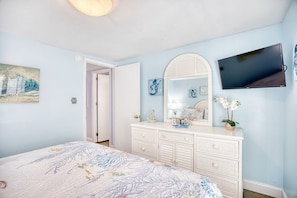 A bedroom with a bed, dresser, mirror, television, and artwork. - Luxury Ocean Front w/ Pool,hotub&basketball court (North Myrtle Beach)
