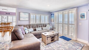A living room with a sectional sofa, a coffee table, and a patterned rug. - 52 Week High (North Myrtle Beach)