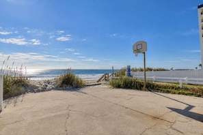 A beachfront property with a basketball court, a wooden staircase leading to the beach, and a white fence. - Luxury Ocean Front w/ Pool,hotub&basketball court (North Myrtle Beach)