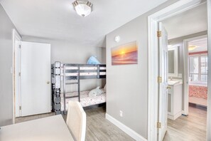 Habitación infantil con literas, una mesa de comedor y vistas al balcón exterior.