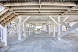 An interior view of a building with a concrete floor, white structural beams, and a staircase on the left. - Luxury Ocean Front w/ Pool,hotub&basketball court (North Myrtle Beach)