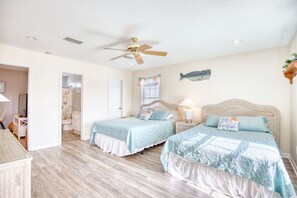 Ein Schlafzimmer mit zwei Betten, einem Deckenventilator und einer Fisch-Wanddekoration.