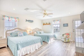 A bedroom with two beds, a ceiling fan, and a view of the outside. - Waterfront Retreat w/ Private Pool in Cherry Grove (North Myrtle Beach)