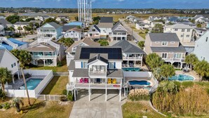 A residential area with houses, a water tower, and a swimming pool. - 5 O'Clock Poolside (North Myrtle Beach)