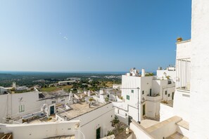 A white building with multiple balconies and a clear view of the surrounding landscape.