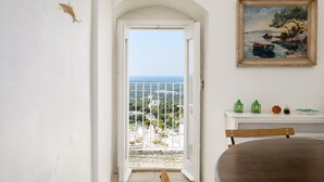 Ein Zimmer mit Balkon, einem Gemälde und einem Tisch mit Dekoration.
